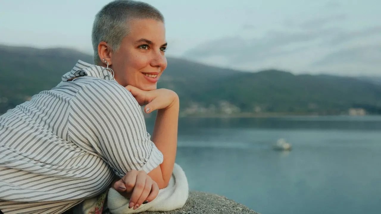 Smiling cancer survivor standing outdoors symbolizing hope and improved mesothelioma survival rates after treatment.