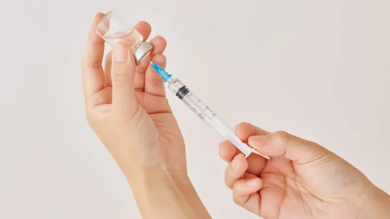 Healthcare professional holding vaccine syringe for childhood immunization schedule 2026
