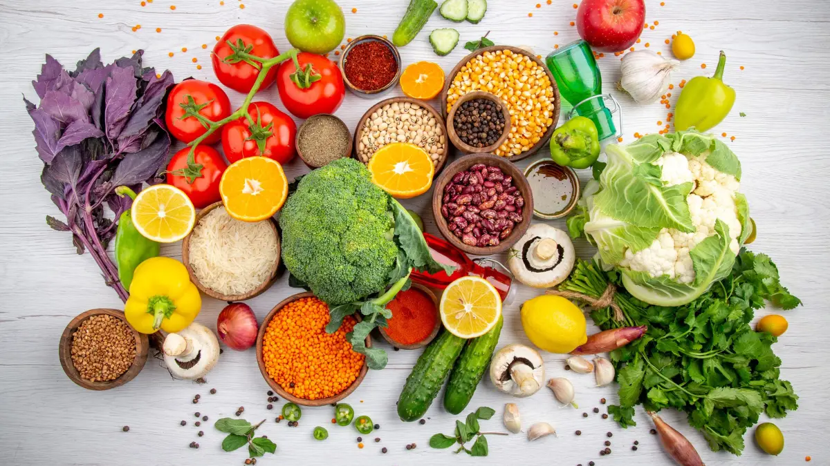Assortment of whole foods including vegetables, grains, fruits, and legumes used for calculating daily macros in a nutrition plan