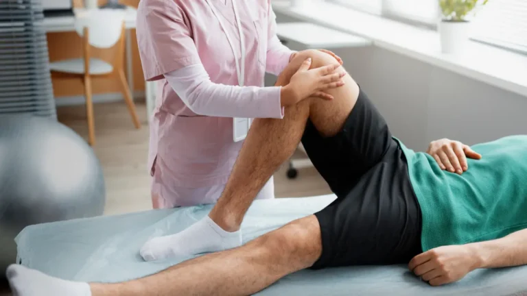 Physiotherapist supporting a patient’s knee during ACL tear recovery and rehabilitation exercises