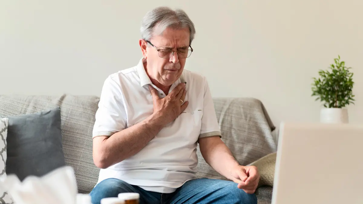 Senior man experiencing chest discomfort and heart attack warning signs at home during holidays