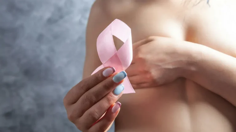 Breast cancer clinical trials featured image showing a woman holding a pink ribbon for breast cancer awareness