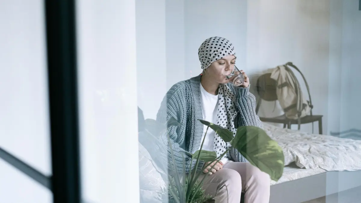 Lung cancer mental health — woman with headscarf representing cancer patient completing NCCN Distress Thermometer self-assessment for anxiety and depression screening at oncology visit
