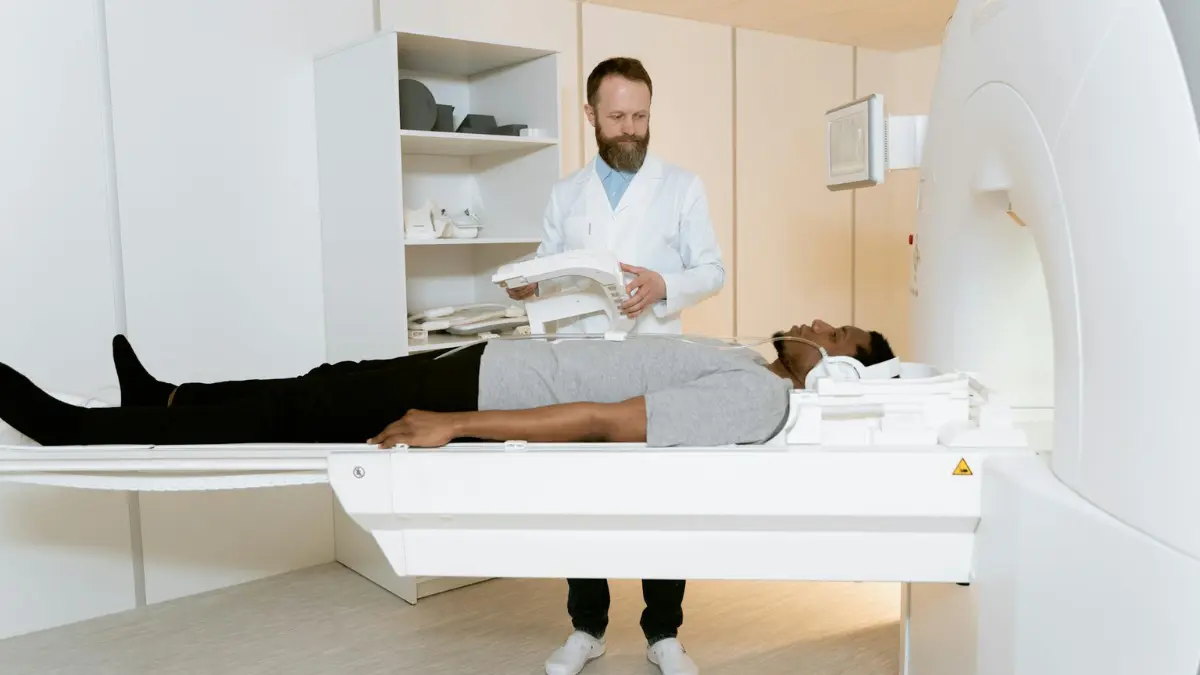 Physician consulting with a patient at a CT scanner to prevent lung cancer through personalized occupational exposure risk assessment and enhanced surveillance beyond standard USPSTF screening criteria