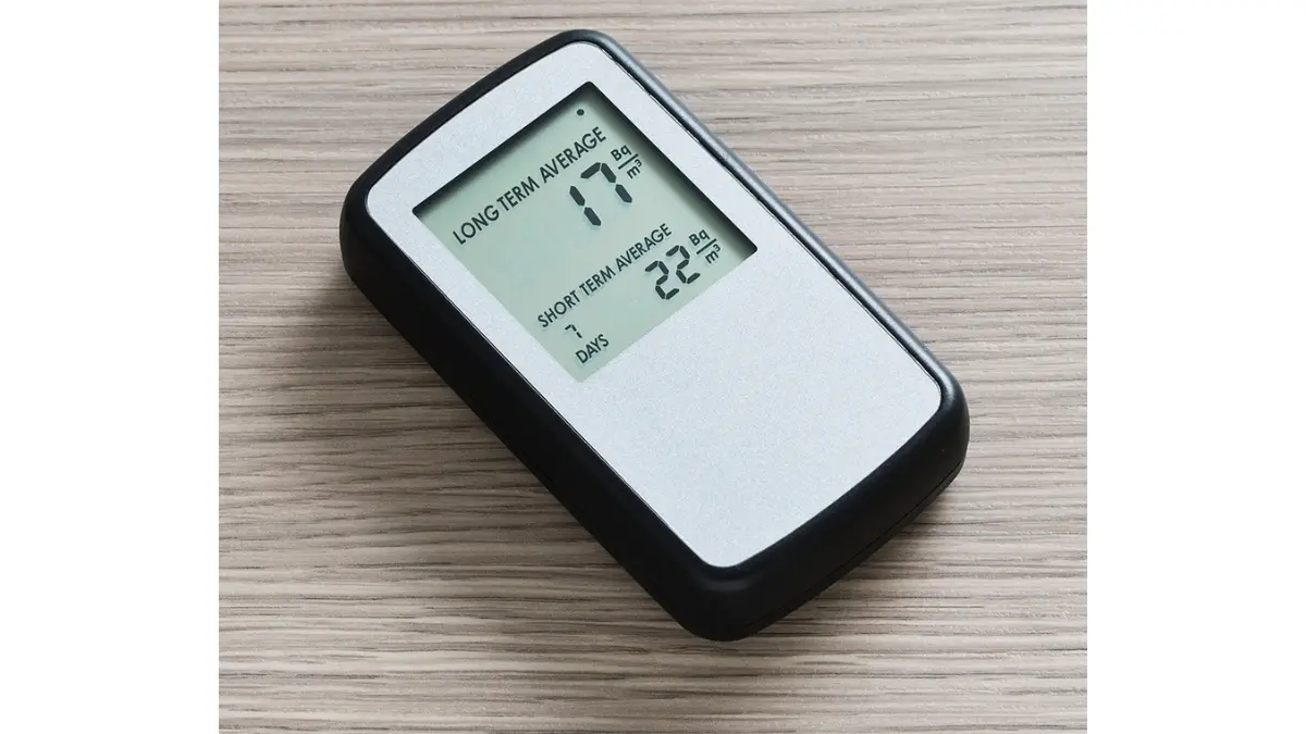 Radon gas home detector device showing a digital reading of indoor radon levels in picocuries per liter, used to test homes for lung cancer risk from radon exposure