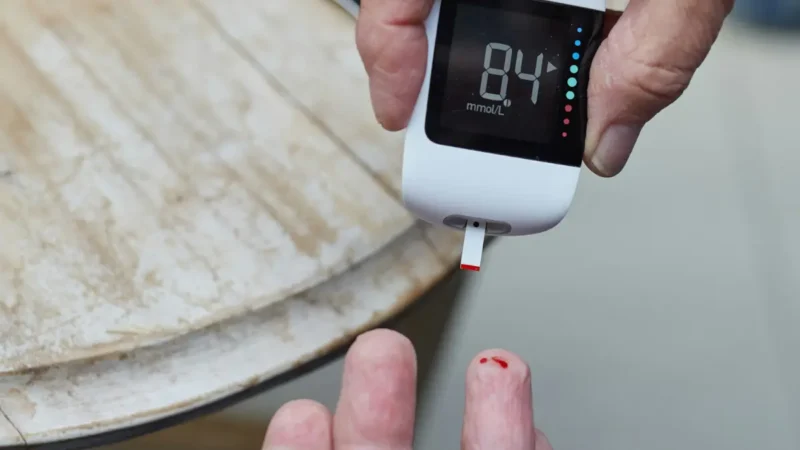 A digital glucometer displaying numeric readouts to evaluate how a CMP detect diabetes markers.
