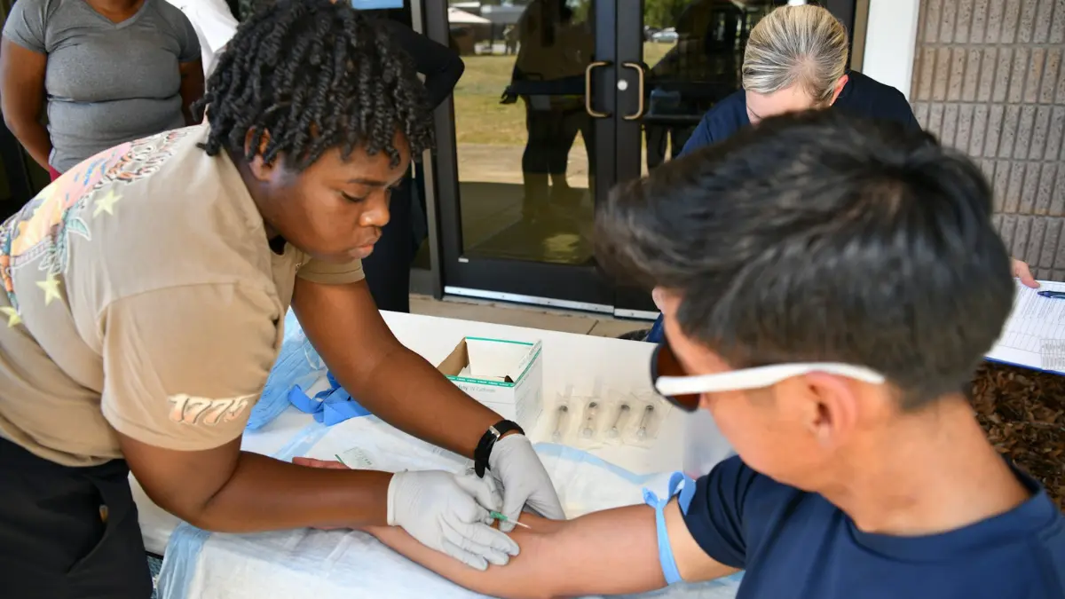 A medical professional performing a clean venipuncture blood draw on a patient's arm to test for high potassium causes.